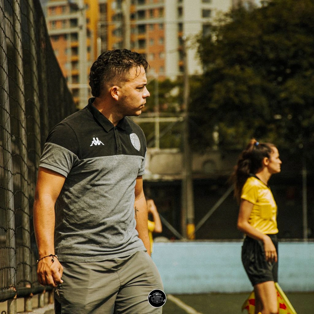 Goalkeeper coach kneeling with gloves at a training session